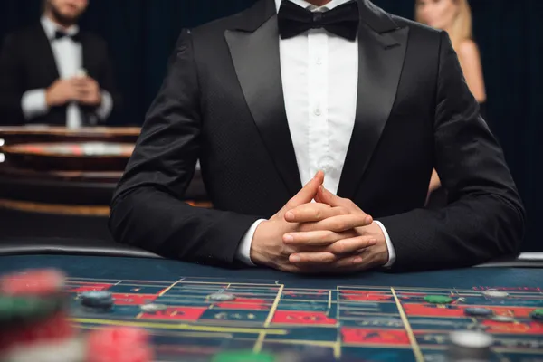 A woman in a luxurious green gown next to an ornate roulette wheel, capturing the upscale casino mood of BIGPARI.